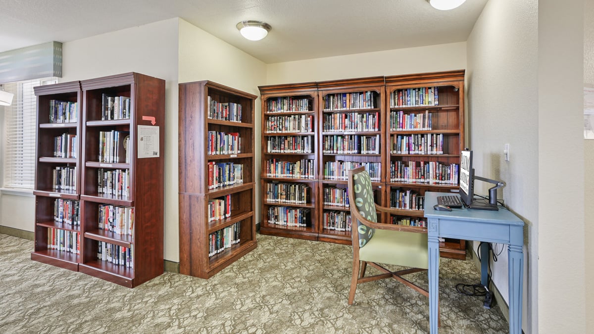 The library at Paloma Landing with shelves of books and comfortable seating